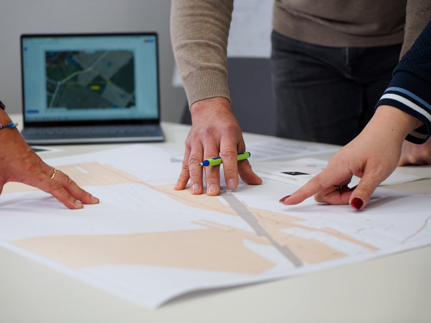 Hände zeigen auf eine Planungskarte